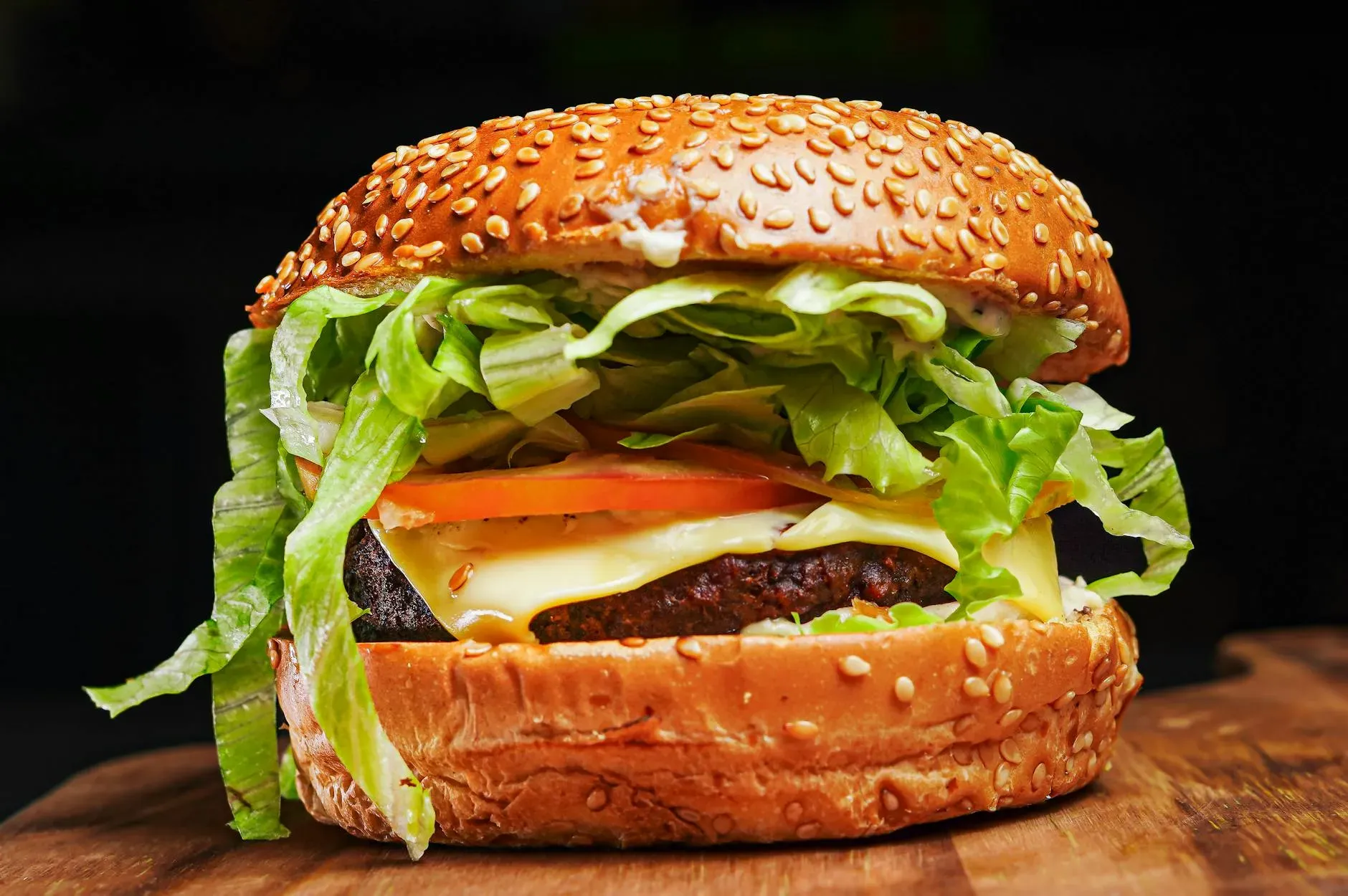 pedro furtado Appetitoso primo piano di un cheeseburger con lattuga, pomodoro e panino al sesamo.
